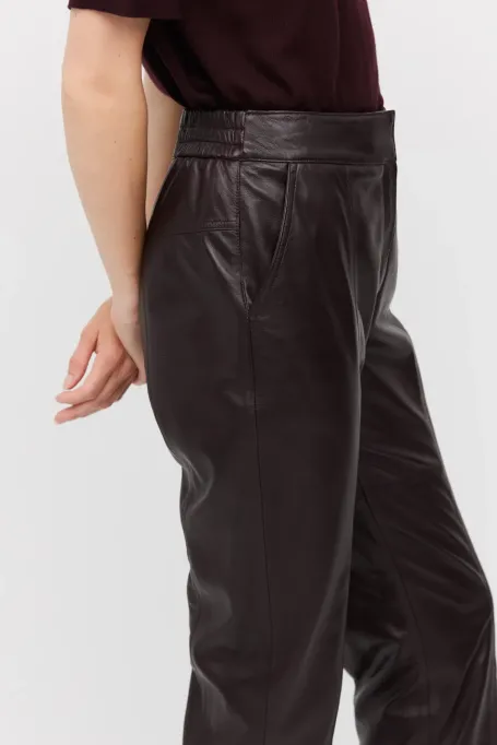 Lila Lederhosen mit Taschen rot